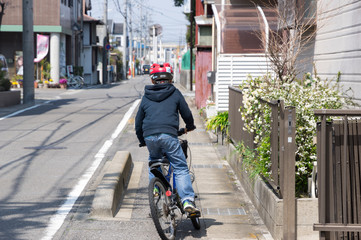 自転車で路地を快走する少年