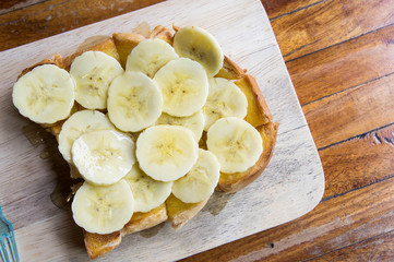 toast banana with honey caramal on table wood