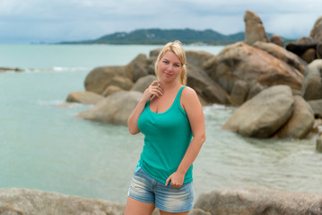 Young blonde woman staying near sea