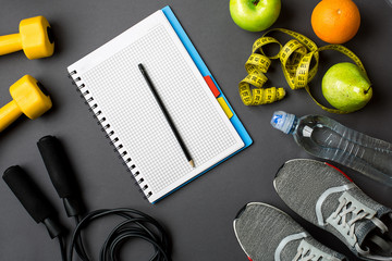 Workout plan with fitness food and equipment on gray background, top view