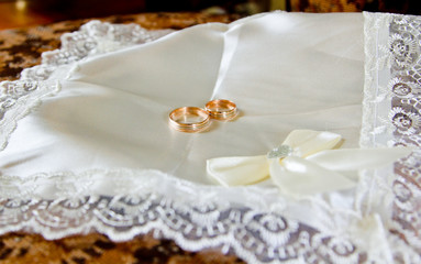 Fototapeta na wymiar Wedding gold rings on a white pillow. Marriage and details