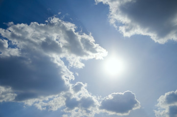 Summer view of the clear blue sky with white clouds and shining sun