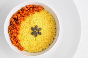 millet porridge boiled with grated cheese served with fried pumpkin and decorated with pumpkin seeds