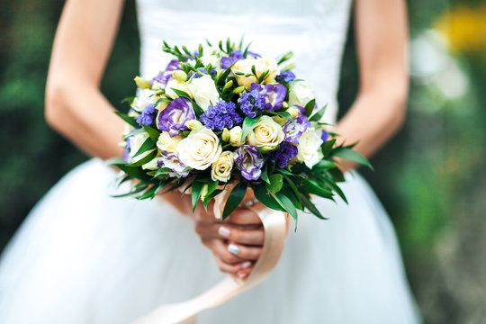Beauty wedding bouquet in bride's hands, close - up
