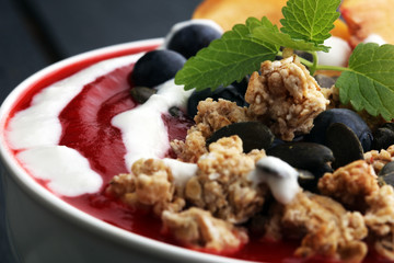 breakfast smoothie bowl with blueberries, peach and granola