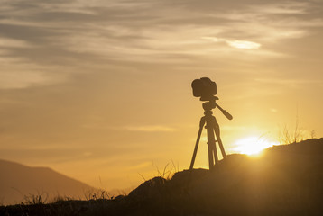 Photo camera at sunset in the mountains