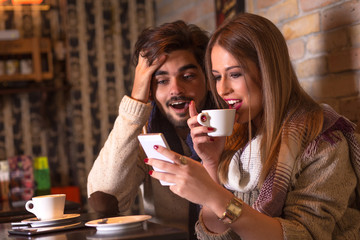 Beautiful young couple in cafe drinking coffee.