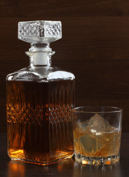 Glass and bottle whiskey on wooden table