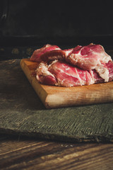  Fresh raw meat - pork (on a kitchen board on a wooden background)