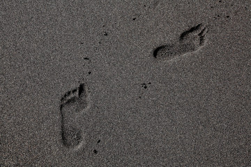 Fototapeta na wymiar Footprints in the black sand