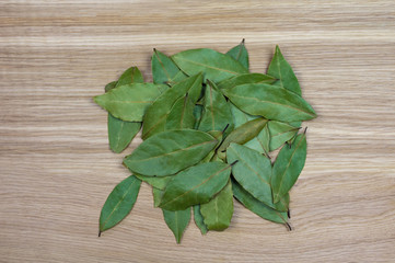 A hill of bay leaves on the oak cutting board, close-up.