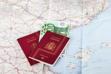 Spanish passports with european union currency on a map background. Travel concept.