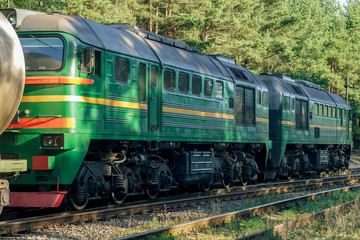 Obraz premium Green diesel cargo locomotive in forest