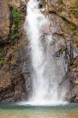 Fototapeta premium close up vertical waterfall in green forest