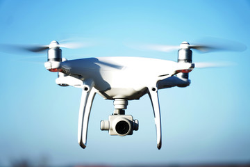 White drone quad copter with summer blue sky - obrazy, fototapety, plakaty