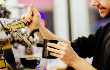 Barista heating milk. Male making coffee and milk..Coffee culture concepts with real people models.