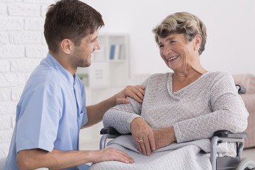 Caregiver comforting elderly woman