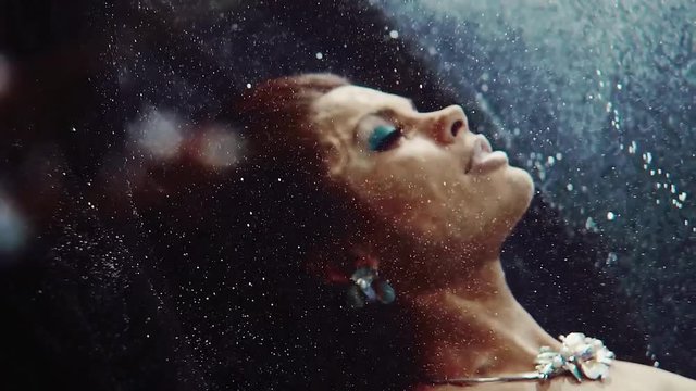 fashionable beautiful woman swims under the water, face in profile