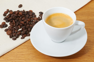 Cup of coffee and coffee beans on the napkin