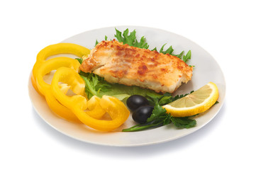 Fried cod fillet with fresh vegetables and slice of lemon