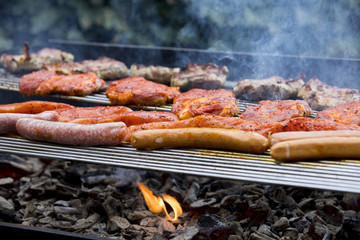 Fleisch und Wurst werden auf einem Grill zubereitet