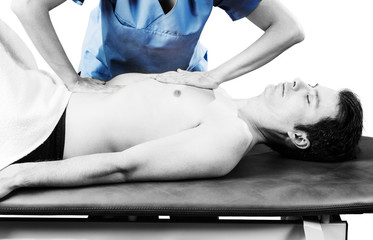 Physiotherapist is doing an activation of the diaphragm. Massage to a man patient in silhouette...