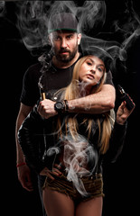 Brutal man and sexy woman are vaping. Studio shooting.