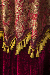 dark maroon and yellow patterned curtains decorated with yellow fringe print