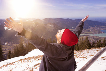 young bearded man surrounded by mountains stretching his arms