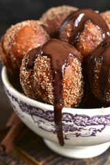 Stack of homemade fried vanilla donut with cinnamon,sugar and chocolate sauce.