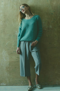 Pretty young girl with blond hair in sunglasses, sweater, culottes