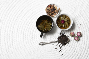 Food background with different black and green dry tea, rose buds cup of hot tea