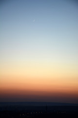 Natural gradient of colors after sunset and a young moon in the sky