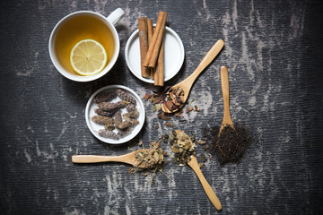 Food background with different black and green dry tea, rose buds cup of hot tea