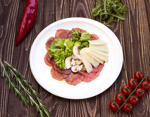 Carpaccio appetizer in rustic background table