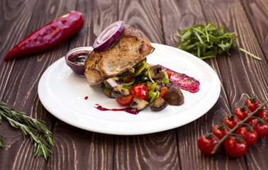 Grilled meat dinner on white plate. Cooked beef steak with vegetables and fresh rosemary