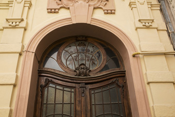 Fragment of arched entrance with stained glass window