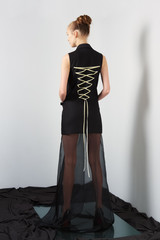 Fashion model in designers black sleeveless jacket and transparent skirt
