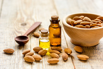 spa with almond oil in organic cosmetic set on wooden background