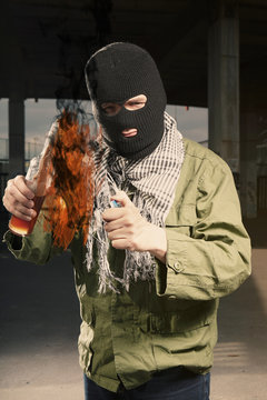 Anarchist in balaclava operating with molotov cocktail glass bomb