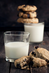 Two glasses of milk and cookies with raisins on wooden table. . Selective focus.