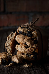 Biscuits with raisins in a craft package on a wooden table. Selective focus.