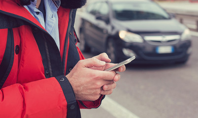 Closeup of a man hands calling a taxi with a smartphone app