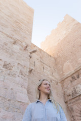 Fototapeta na wymiar Photo of a beautiful blonde woman against the rustic church wall in France in Marseille