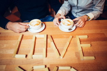 couple hands of coffee on a wooden table