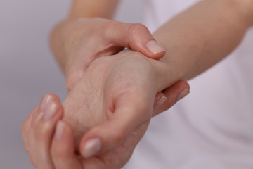 Woman hands checking heart rate pulse on wrist close up