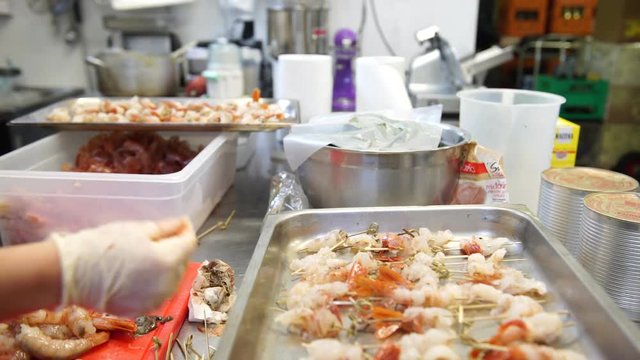 A female cook cleaning shrimps and preparing shrimp skewers, 4K