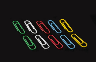 Colored paper clips on a black background