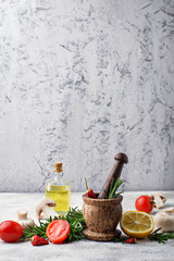 Tomatoes, mushrooms, lemon, oil and mortar with pepper