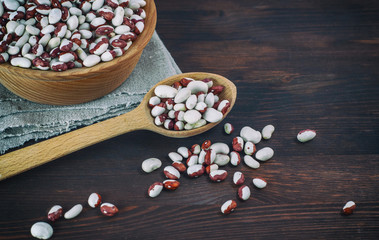 Beans in a wooden spoon on a wooden table